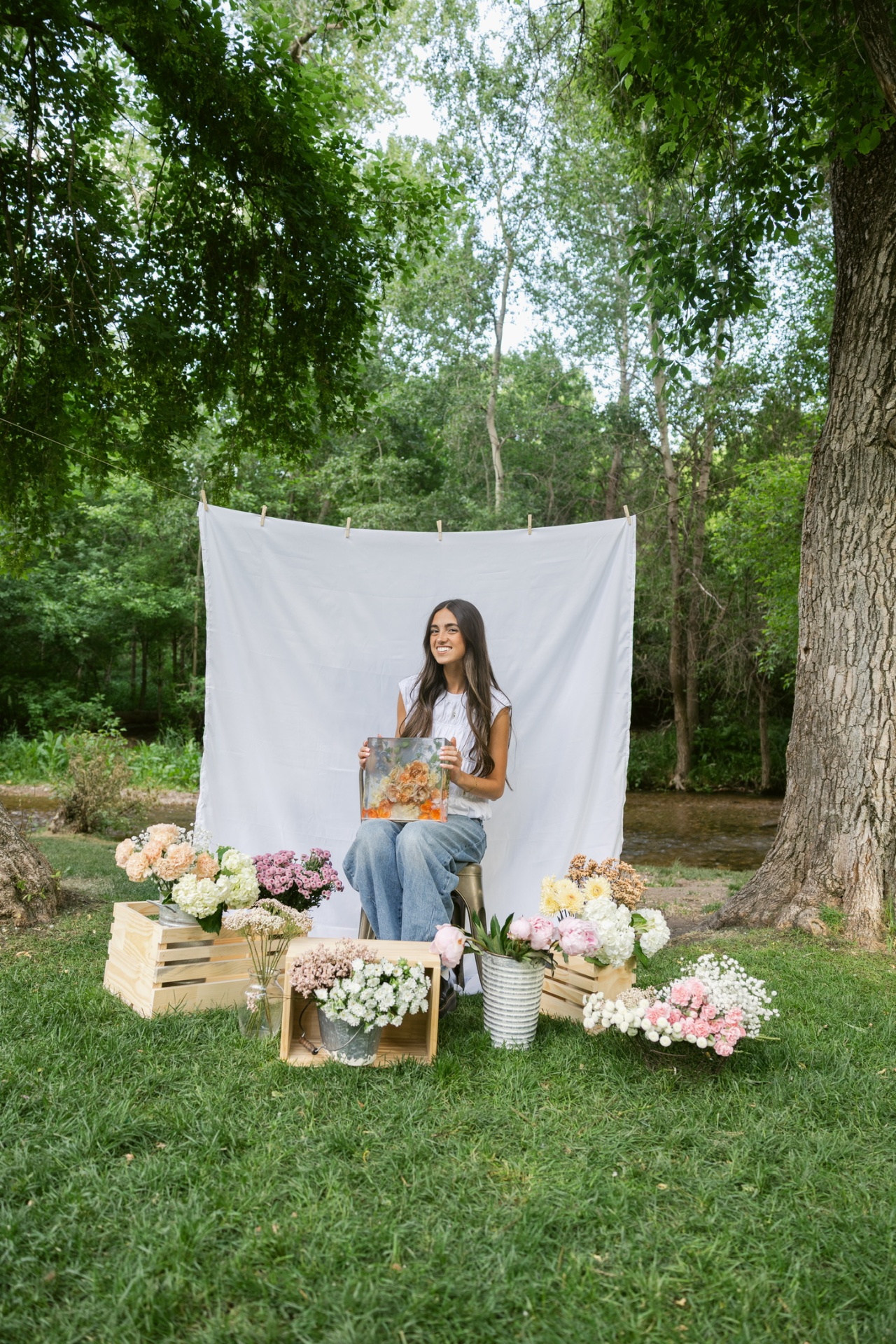Aubrey holding a resin piece surrounded by flowers